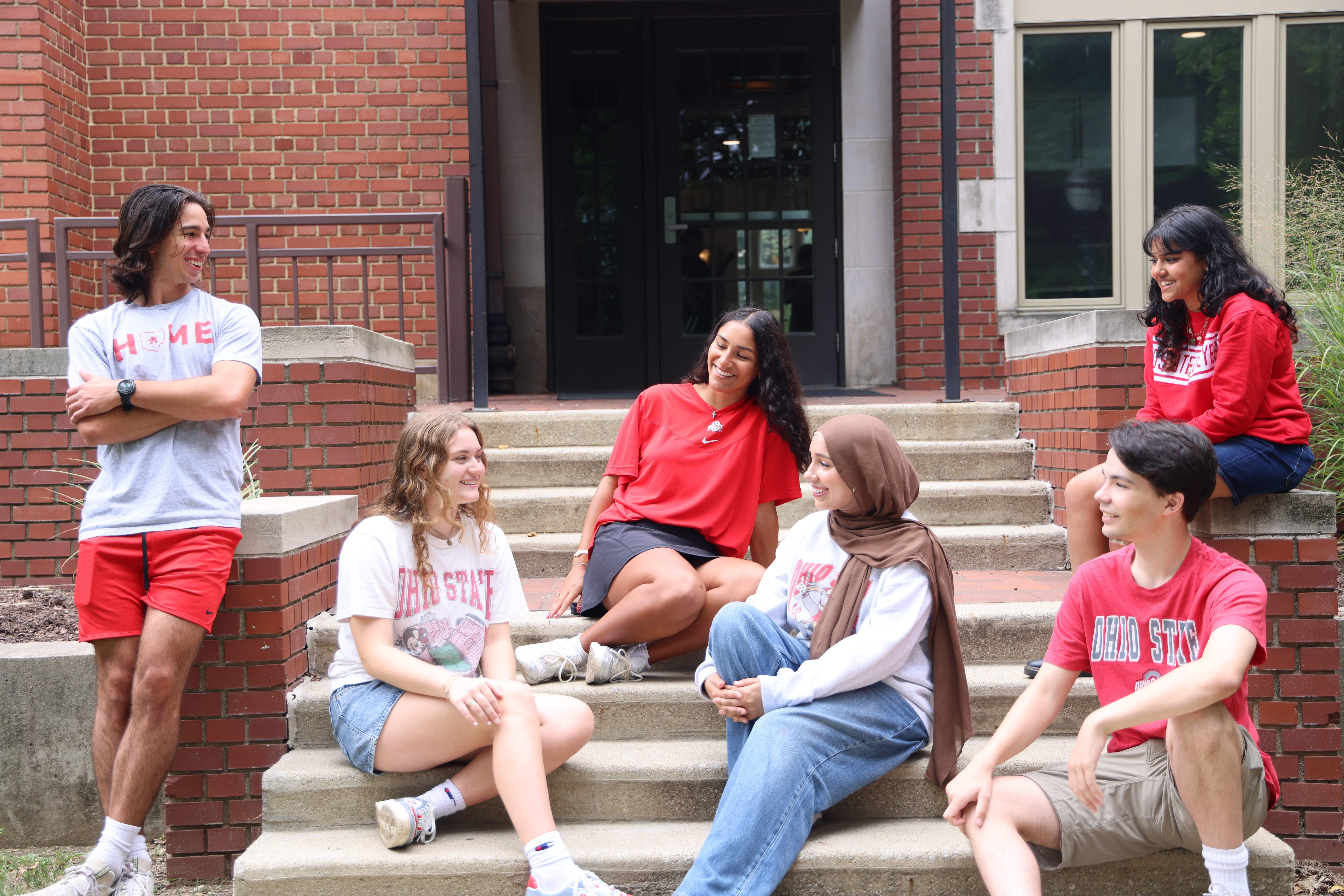 A group of Honors students sitting on the steps outside Kuhn House