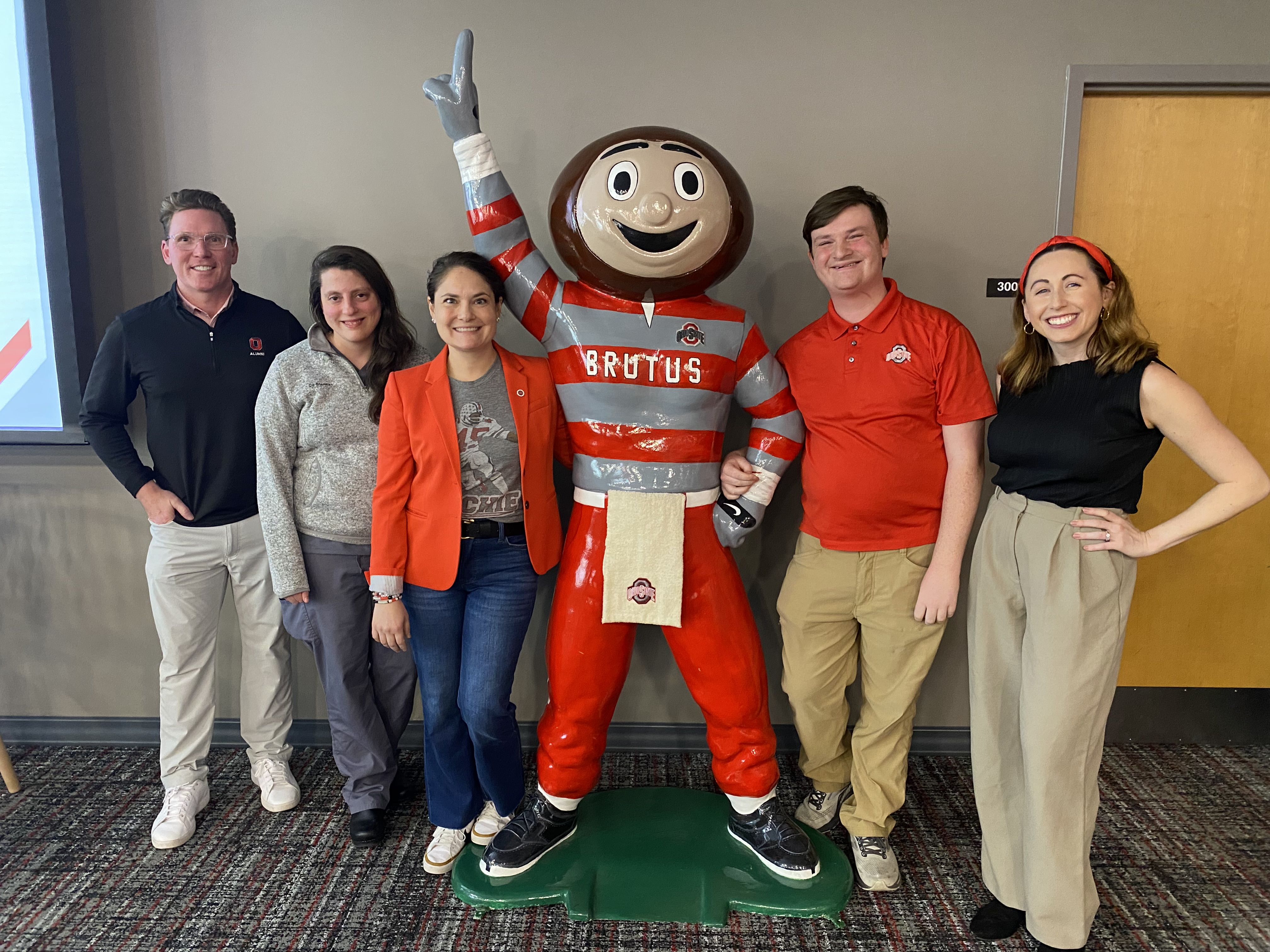 Alumni Board members posing with a statue of Brutus Buckeye 