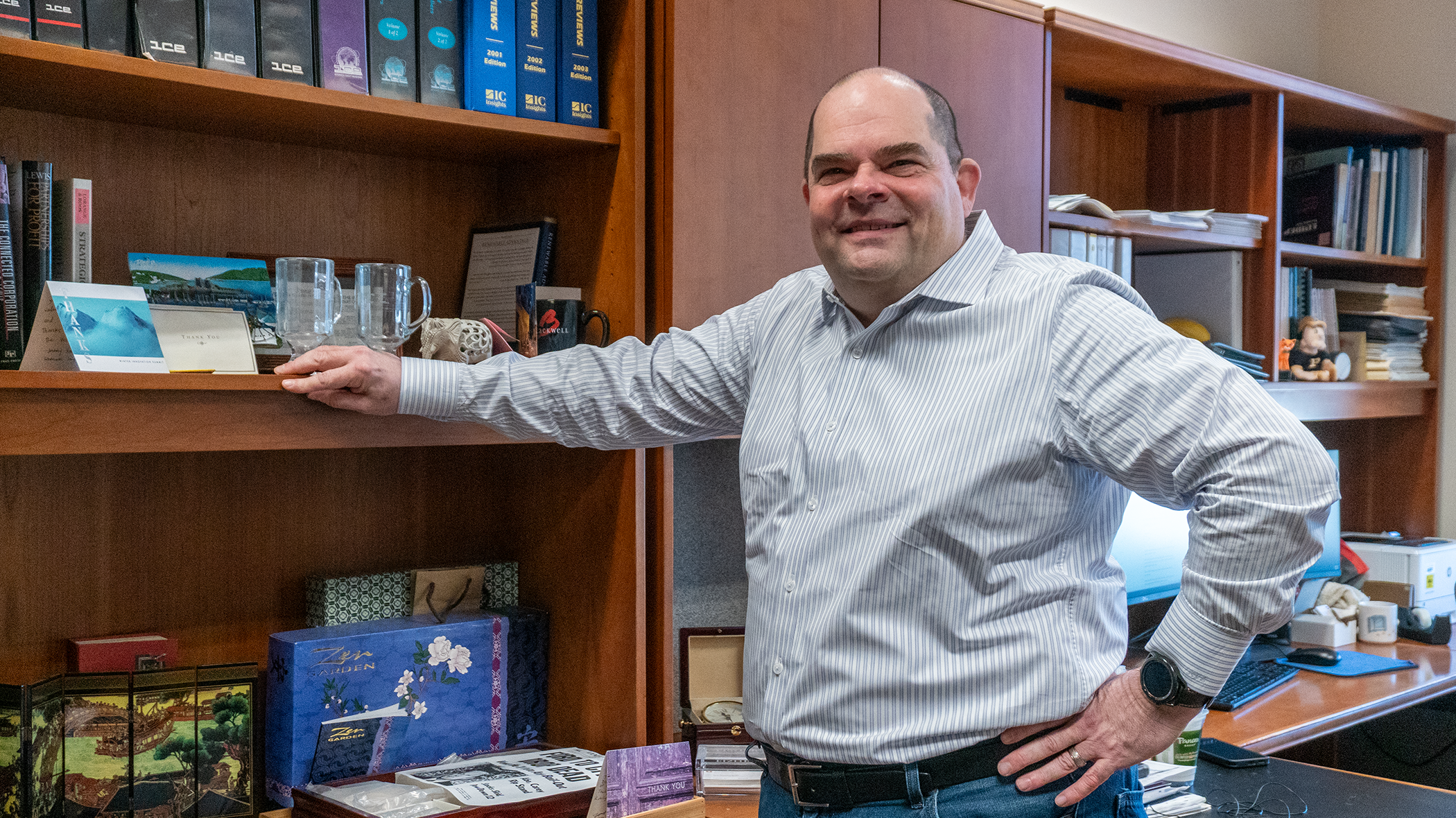 Michael Leiblein standing by bookshelf in his office