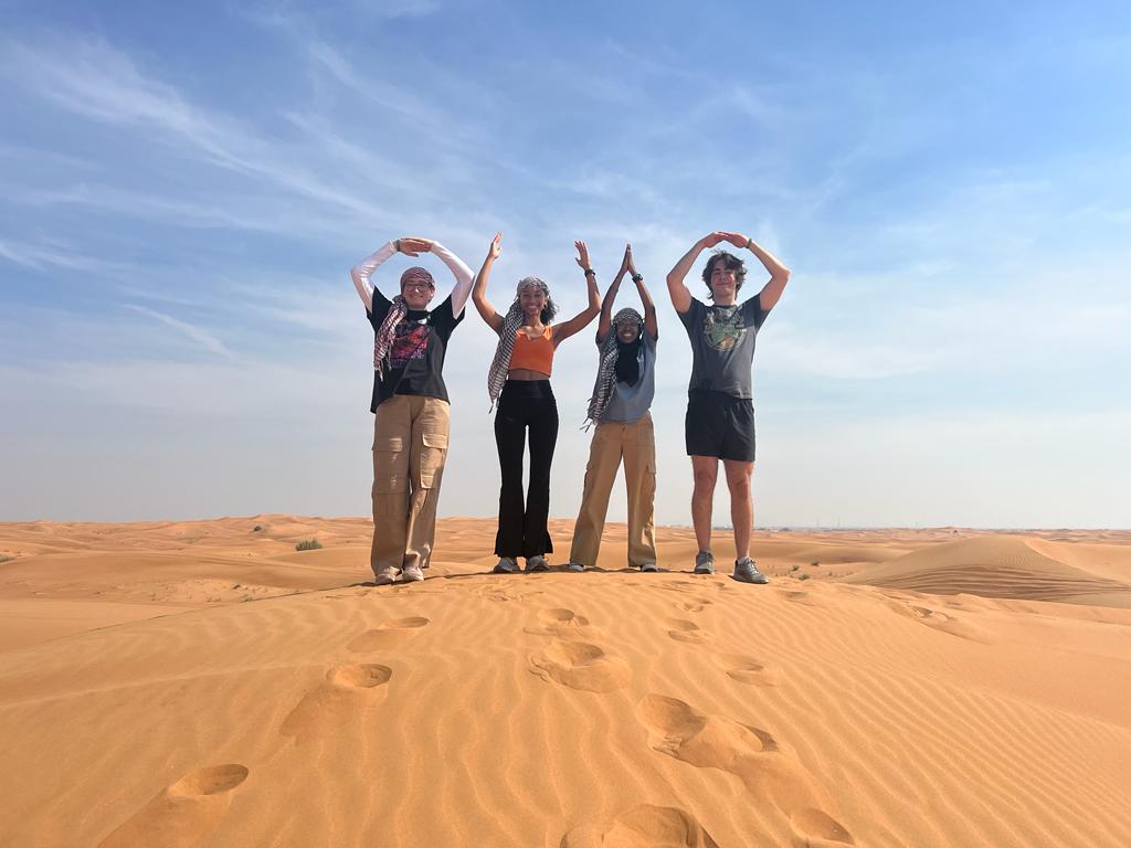 Luke with fellow COP28 attendees doing an O-H-I-O in the desert.