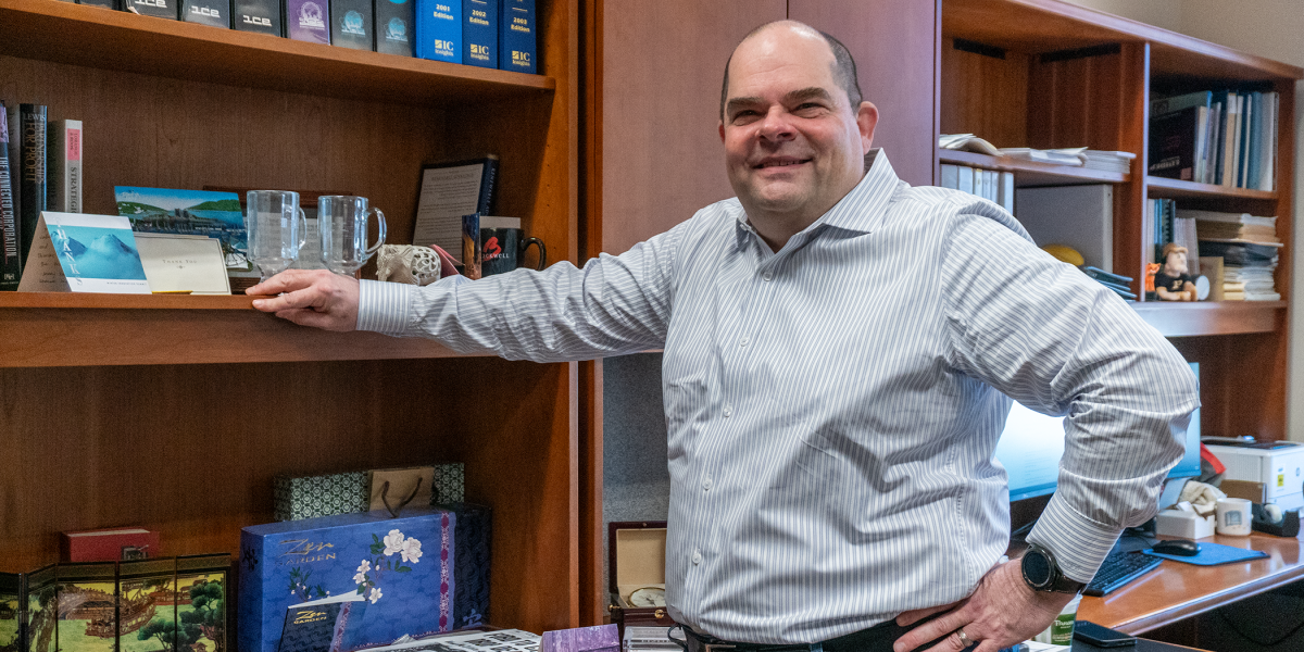 Michael Leiblein standing by bookshelf in his office