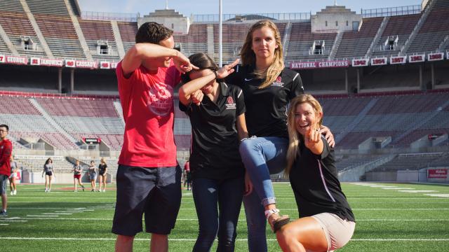 Dunn Sport and Wellness Scholars students doing a fun pose on the Ohio Stadium field
