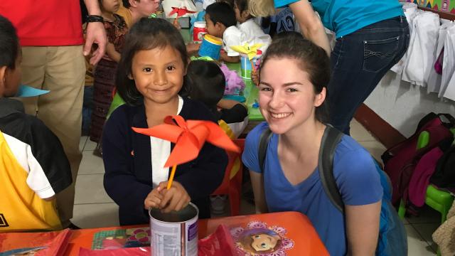 Humanitarian Engineering Scholars student with a child in a classroom