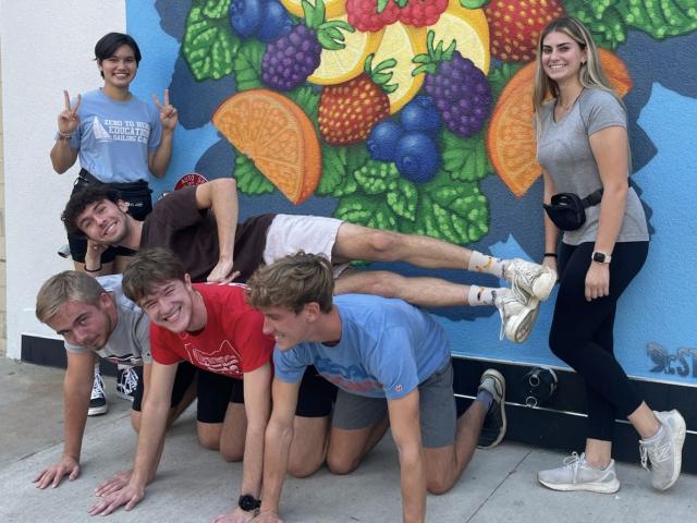 Engineering Scholars posing in front of a mural during a scavenger hunt activity