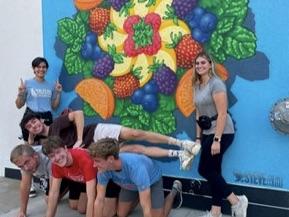 Engineering Scholars posing in front of a mural during a scavenger hunt activity