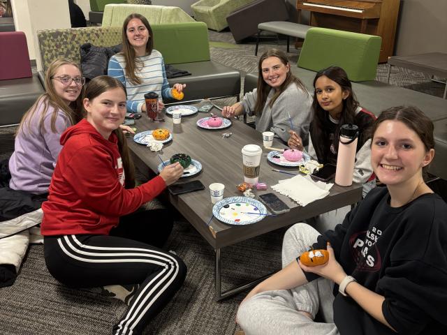 Scholars participate in a pumpkin painting community event