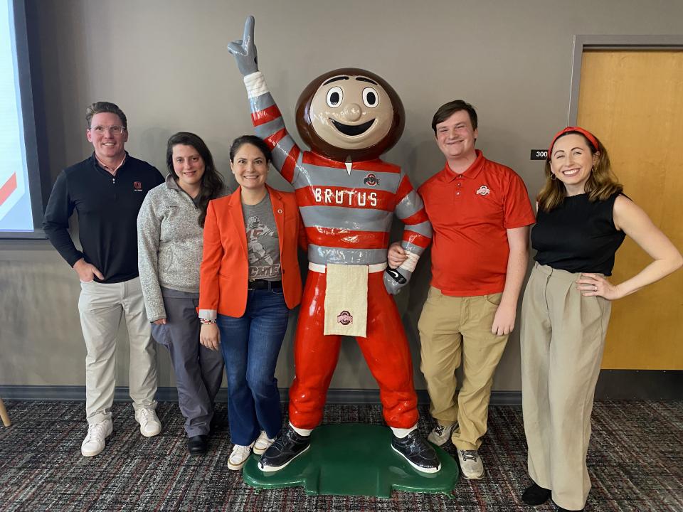 Alumni Board members posing with a statue of Brutus Buckeye